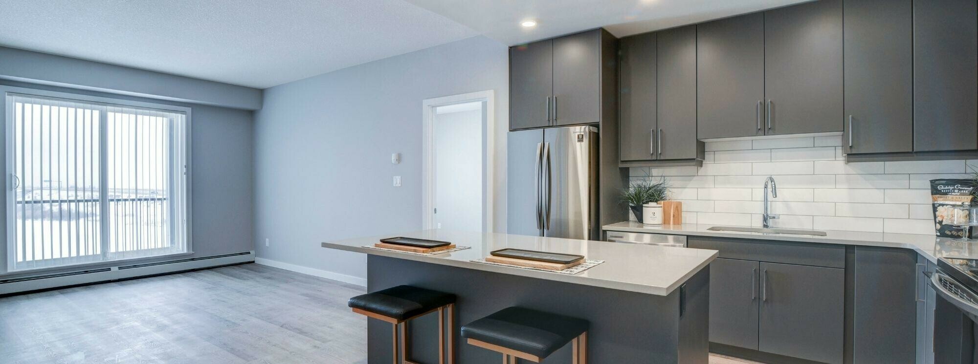 Sora Kitchen in Graphite package overlooking living area and patio doors