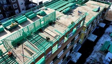 Condo building at framing stage showing green lumber indicating fire retardant coating